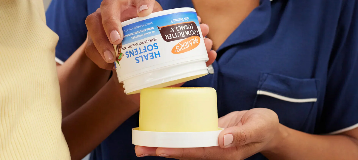Close up of woman and child opening jar of Palmer's Cocoa Butter Formula 