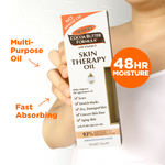 Hand holding Palmer's Cocoa Butter Skin Therapy Oil with Vitamin E box.